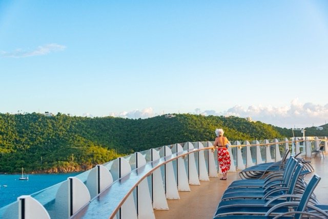 Cruise expert warns solo travellers over hidden booking cost that can almost double holiday price A solo traveller looking out over a green island from the deck of a cruise ship